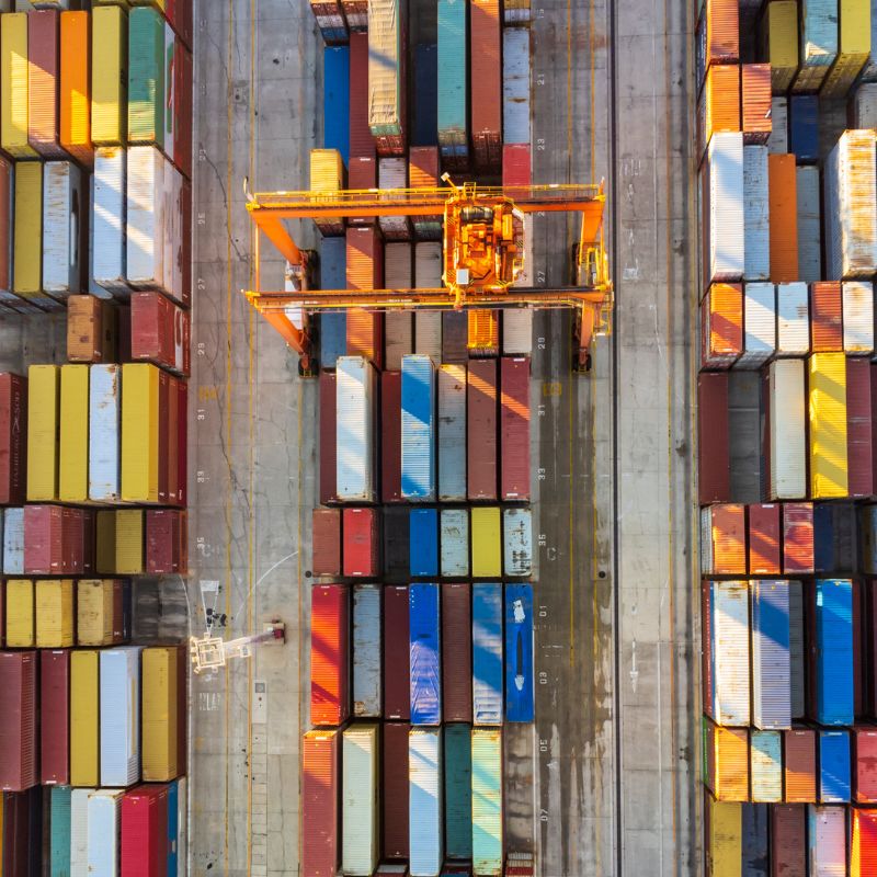 A shot from above to a number of cargo containers lined in marine ready to be transported.