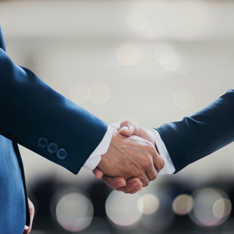 The handshake of two businessmen wearing their suits agreeing on a partnership.